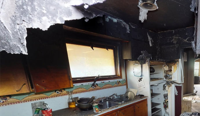 A fire damaged kitchen with soot and smoke damage