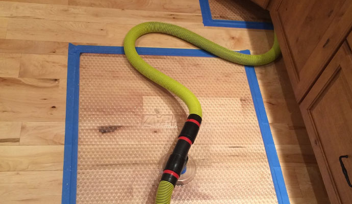 A hardwood floor drying mat with a yellow hose