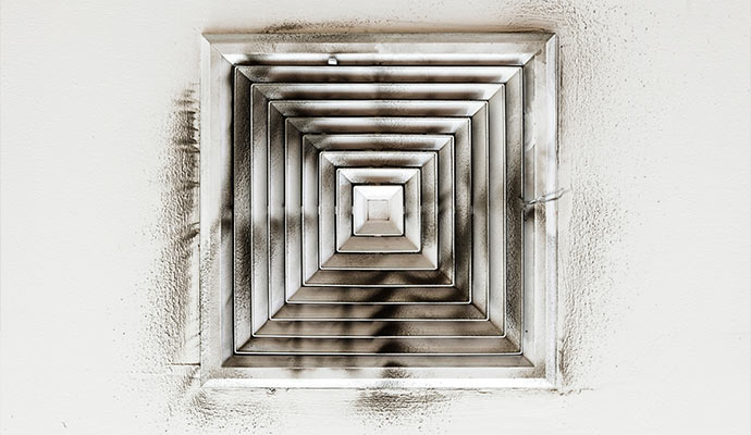 A sooty ceiling vent from duct system smoke damage