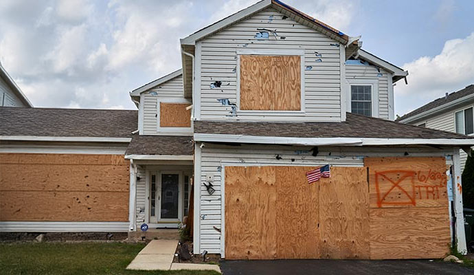 Boarded up storm damaged house