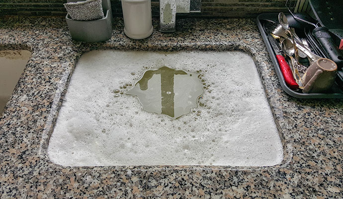 Clogged kitchen sink with soapy water