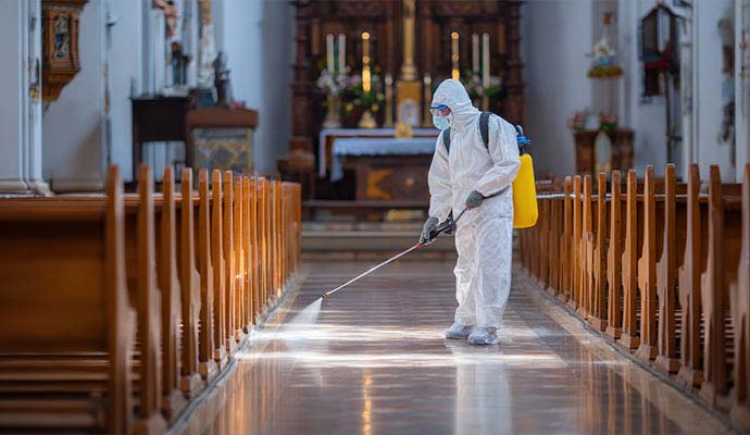 Expert spraying disinfectant inside church