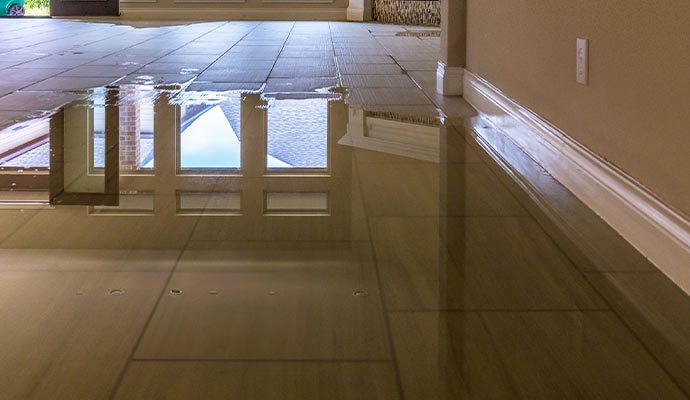 Indoor floor covered with standing water reflecting windows after flooding