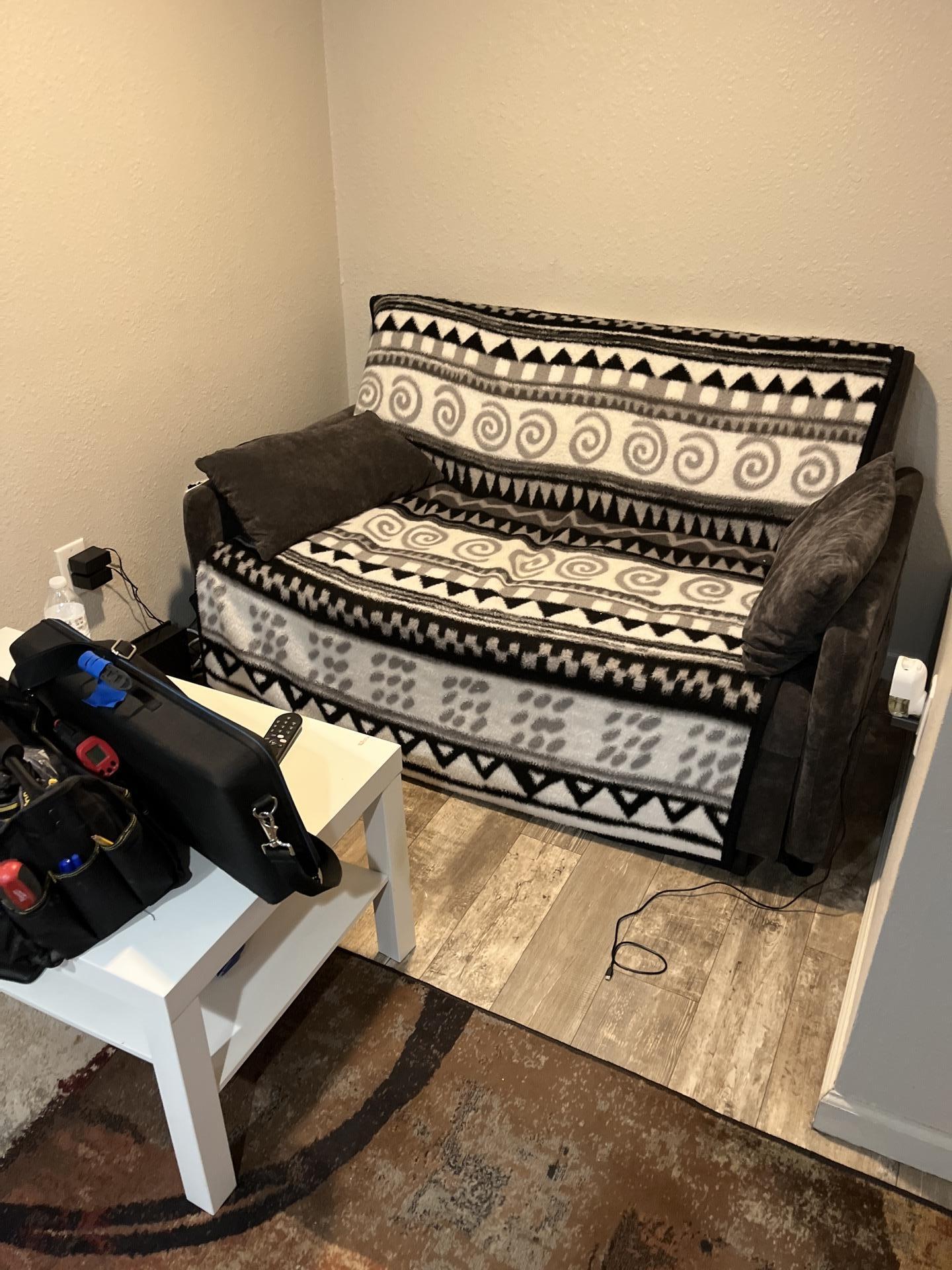 A living room or bedroom space, showing furnishings within an area affected by water damage, undergoing restoration by Alpha Omega Restoration Pros.