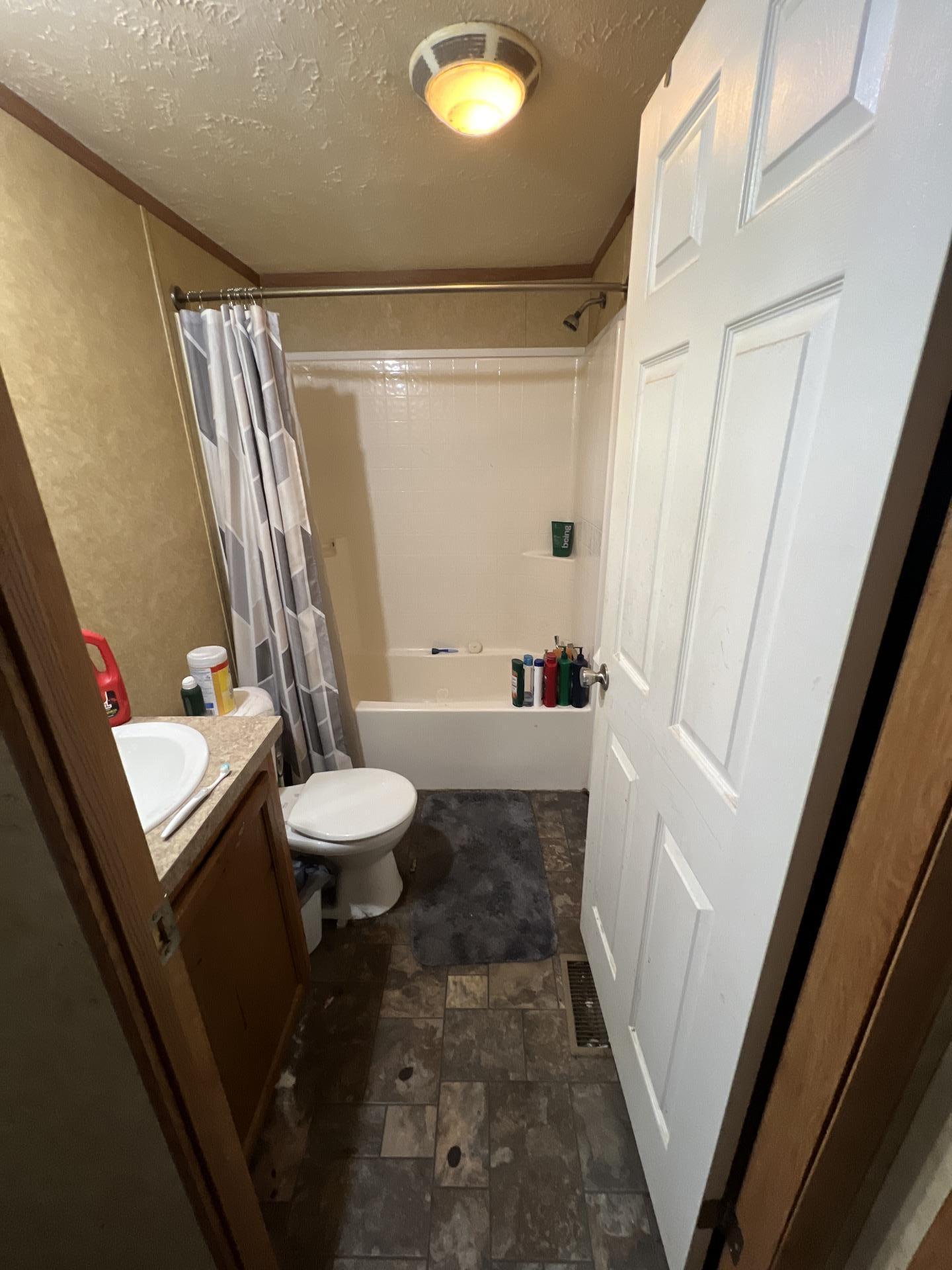 Close-up of warped bathroom cabinetry caused by significant moisture exposure. Our property restoration team performed a detailed assessment to initiate water mitigation and structural drying