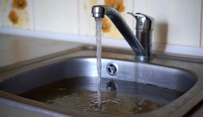 Overflowing kitchen sing with running water