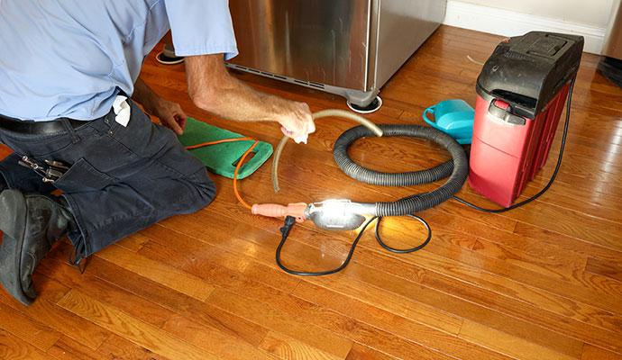 Professional worker repairing a refrigerator
