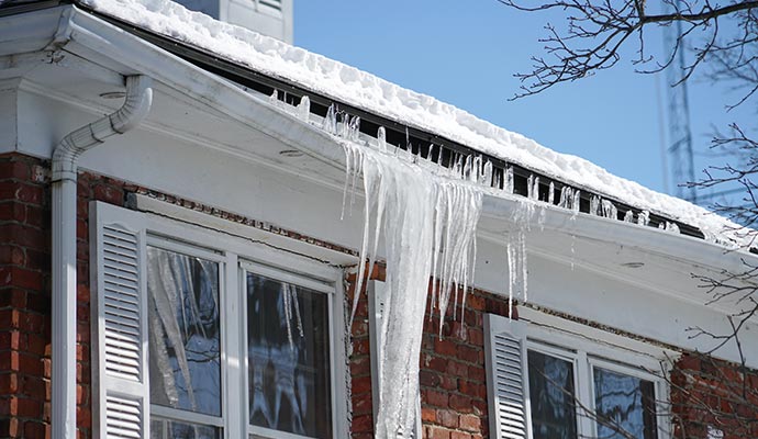 Damaged roof covered with ice after heavy snowfall