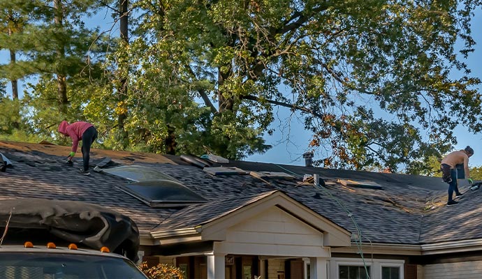 Professional team performing roof damage restoration on a residential property
