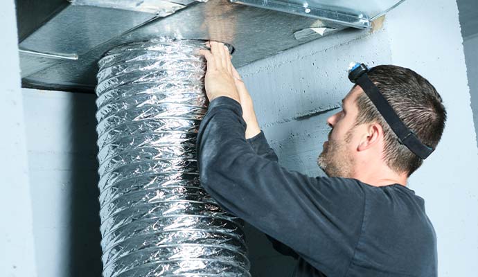 Technician installing flexible HVAC air duct