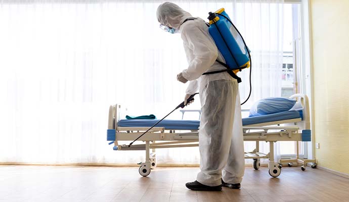 Technician disinfecting hospital room