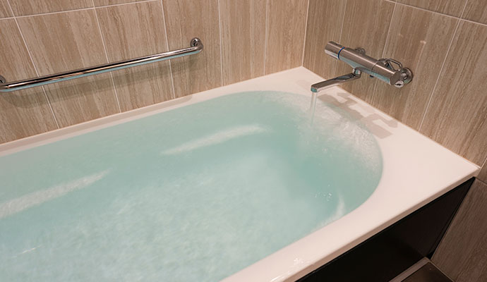 Modern bathroom bathtub filling with running water